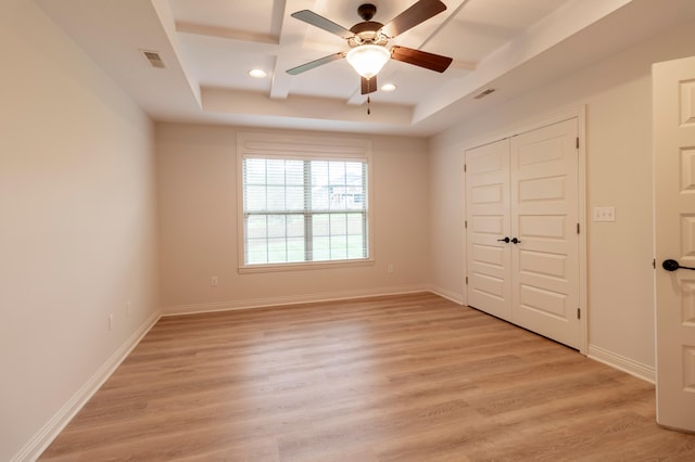 spare room featuring light wood-style floors, a ceiling fan, and visible vents