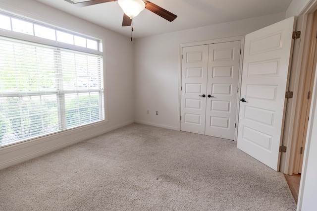 unfurnished bedroom featuring ceiling fan, baseboards, carpet, and a closet