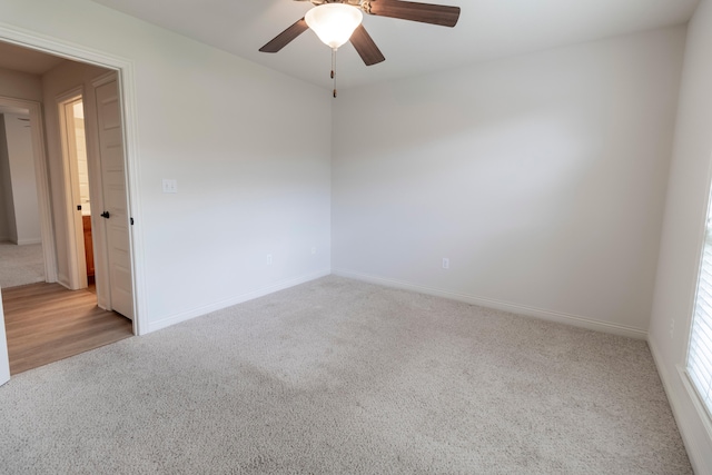 carpeted spare room with baseboards and a ceiling fan