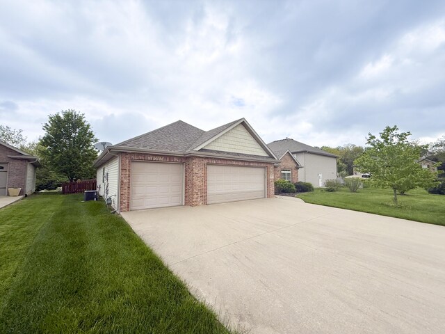 ranch-style home with a garage, a front yard, roof with shingles, brick siding, and driveway
