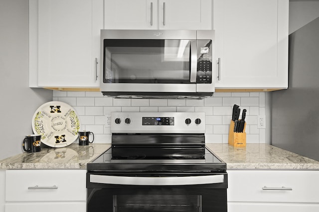 kitchen with white cabinetry, light stone counters, tasteful backsplash, and appliances with stainless steel finishes