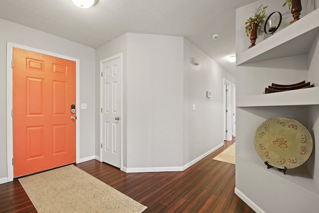 foyer with dark wood-type flooring and baseboards