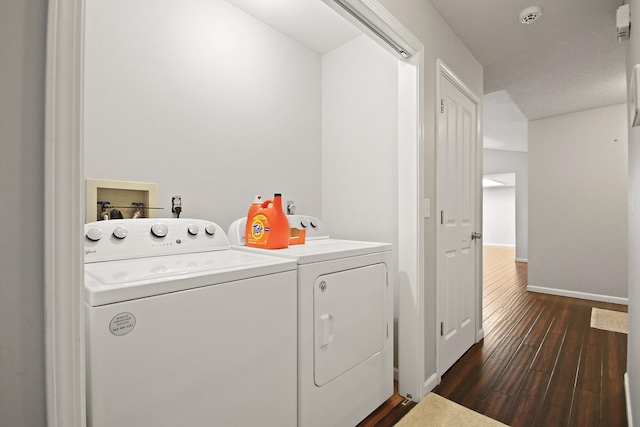 clothes washing area featuring washing machine and clothes dryer, laundry area, baseboards, and dark wood-style floors