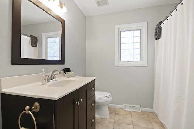 bathroom with tile patterned floors, toilet, a healthy amount of sunlight, and visible vents