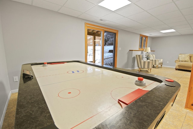 playroom with a paneled ceiling and baseboards