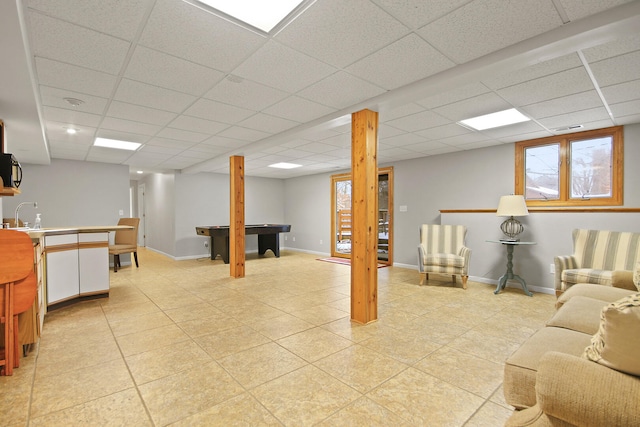 living area with light tile patterned floors, visible vents, a paneled ceiling, and baseboards