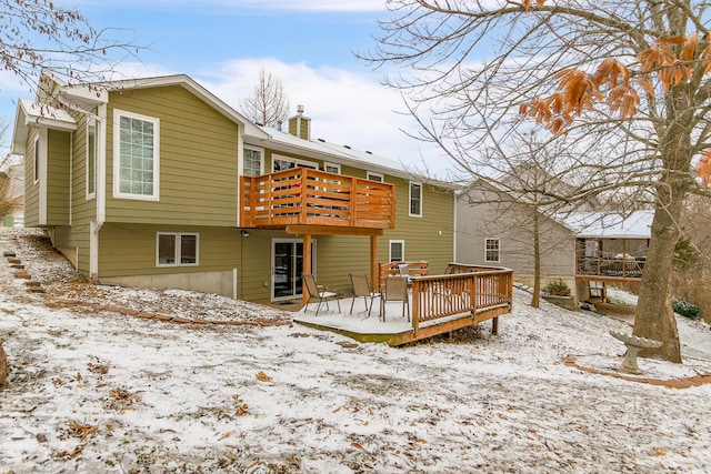 snow covered property featuring a deck and a chimney