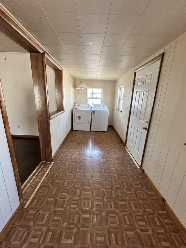 laundry area featuring washer and dryer, baseboards, wooden walls, and laundry area