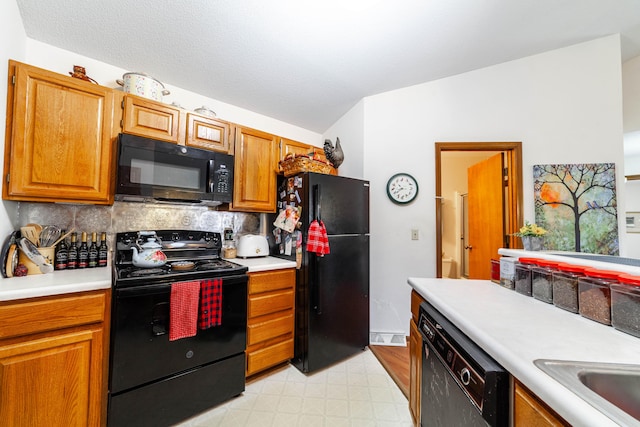 kitchen featuring light floors, black appliances, light countertops, brown cabinets, and backsplash