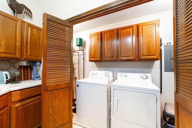 laundry area featuring electric panel, independent washer and dryer, and cabinet space