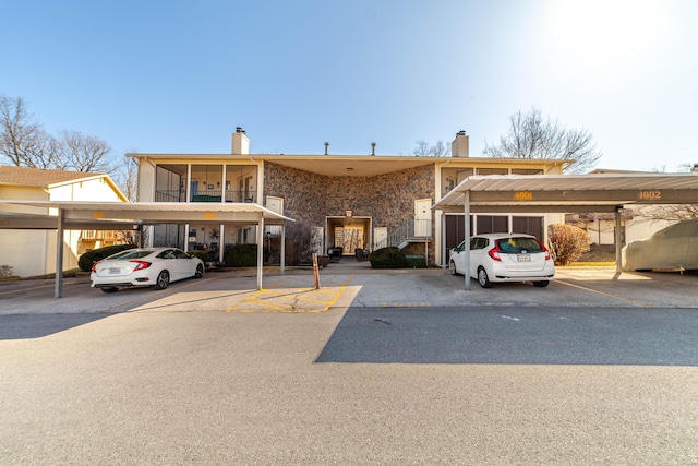 view of front of home with covered parking and a chimney