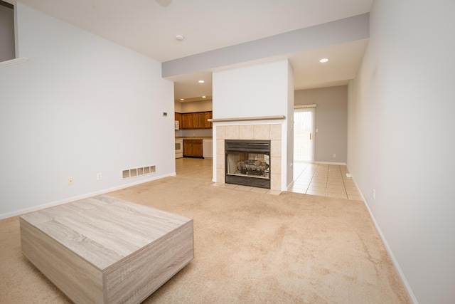 living room featuring visible vents, light carpet, recessed lighting, baseboards, and a tile fireplace