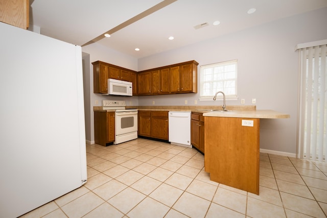 kitchen with visible vents, a sink, white appliances, a peninsula, and light countertops