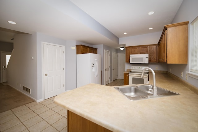 kitchen with white appliances, visible vents, a peninsula, recessed lighting, and a sink