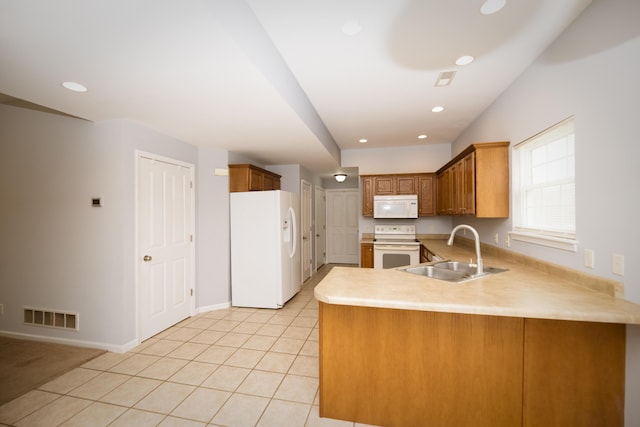 kitchen featuring visible vents, light tile patterned floors, a peninsula, white appliances, and a sink