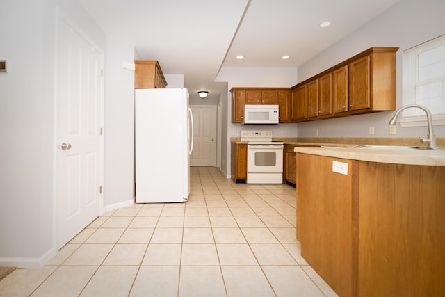 kitchen featuring white appliances, light tile patterned floors, brown cabinetry, a sink, and light countertops