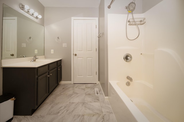 bathroom featuring washtub / shower combination, baseboards, marble finish floor, and vanity