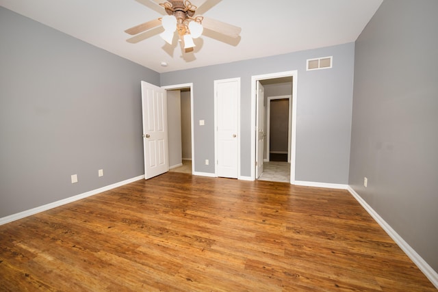 unfurnished bedroom with visible vents, baseboards, and wood finished floors