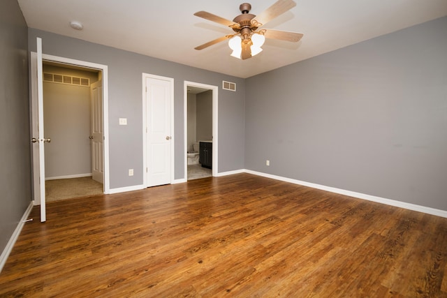 unfurnished bedroom featuring visible vents, baseboards, and wood finished floors