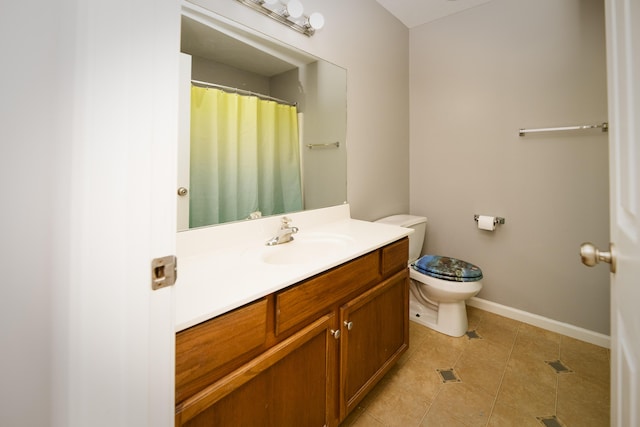 bathroom with tile patterned flooring, toilet, vanity, and baseboards