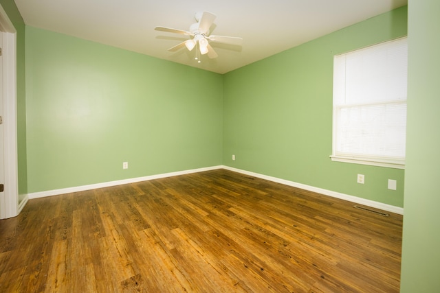 unfurnished room featuring a ceiling fan, wood finished floors, and baseboards