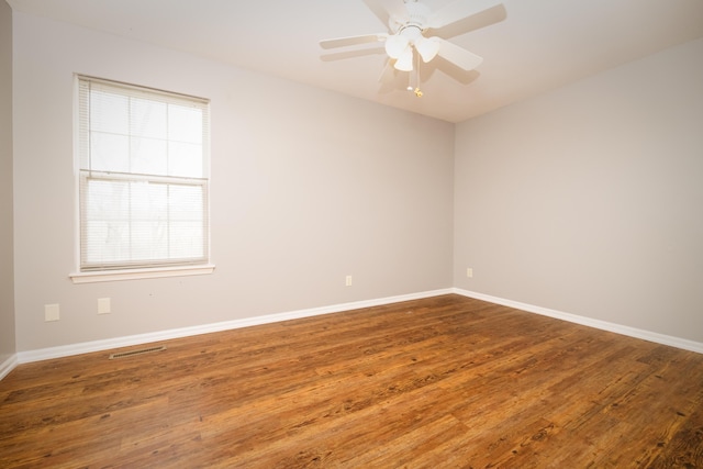 empty room with visible vents, baseboards, and wood finished floors