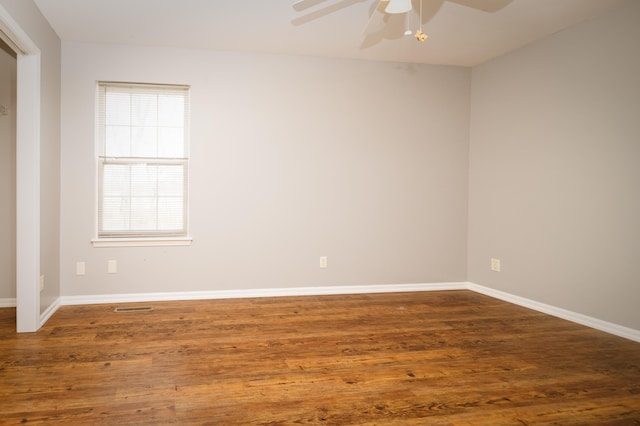 unfurnished room with baseboards, wood finished floors, visible vents, and ceiling fan