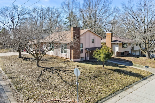 view of front of home featuring board and batten siding, a chimney, and driveway