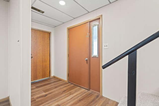 foyer entrance with light wood-type flooring, visible vents, and a paneled ceiling