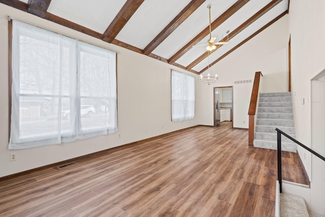 unfurnished living room featuring stairway, visible vents, and beamed ceiling