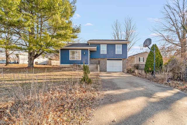 split level home featuring brick siding, driveway, and an attached garage