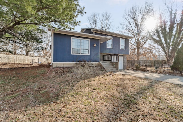 view of front facade with a garage, concrete driveway, and fence