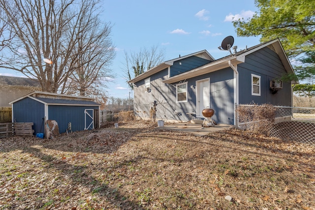 rear view of house with an outbuilding, a storage shed, and fence