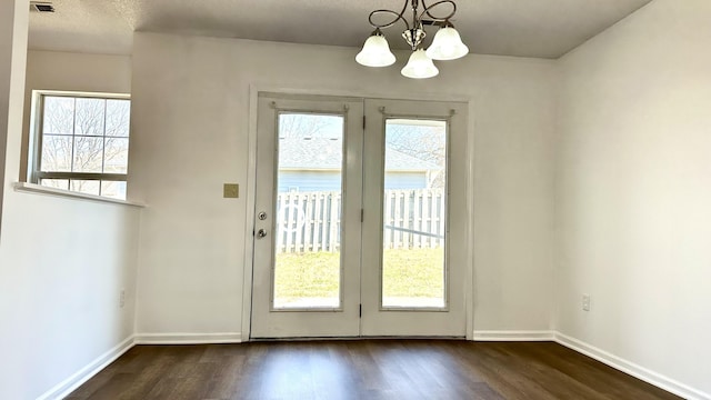 doorway with baseboards, a healthy amount of sunlight, and dark wood-style floors