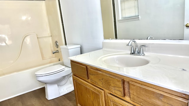 full bathroom featuring washtub / shower combination, toilet, wood finished floors, and vanity