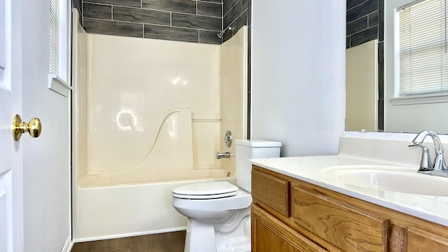 bathroom featuring vanity, toilet, wood finished floors, and shower / bath combination