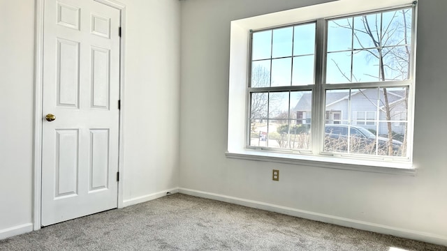 carpeted empty room with baseboards and plenty of natural light