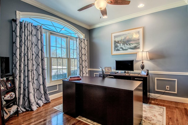 office area with a wainscoted wall, ornamental molding, wood finished floors, baseboards, and ceiling fan