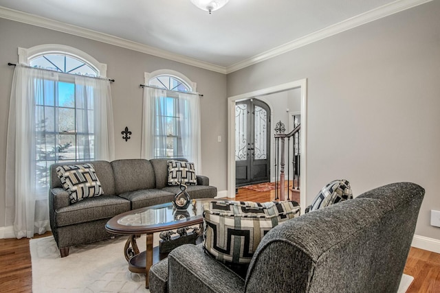 living area featuring baseboards, wood finished floors, and ornamental molding