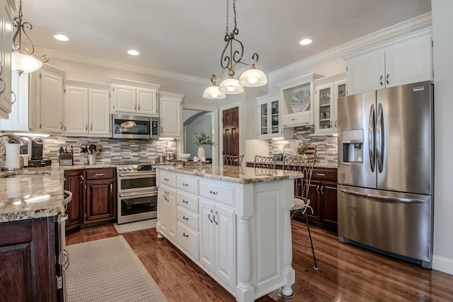 kitchen featuring a sink, stainless steel appliances, a kitchen island, and white cabinets