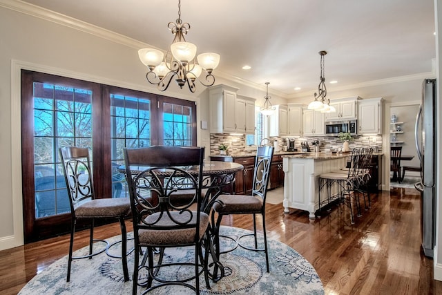 dining area featuring crown molding, a notable chandelier, and dark wood-style floors