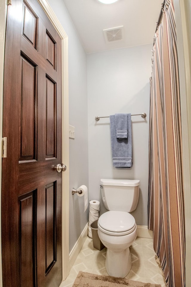 bathroom with tile patterned flooring, visible vents, toilet, and baseboards