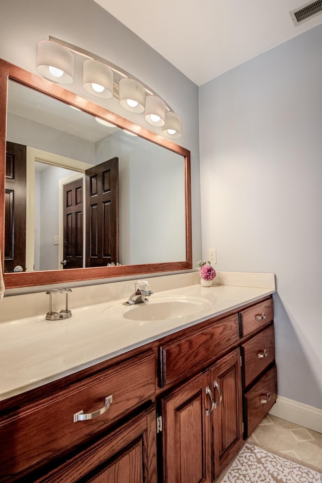 bathroom featuring tile patterned floors, visible vents, baseboards, and vanity