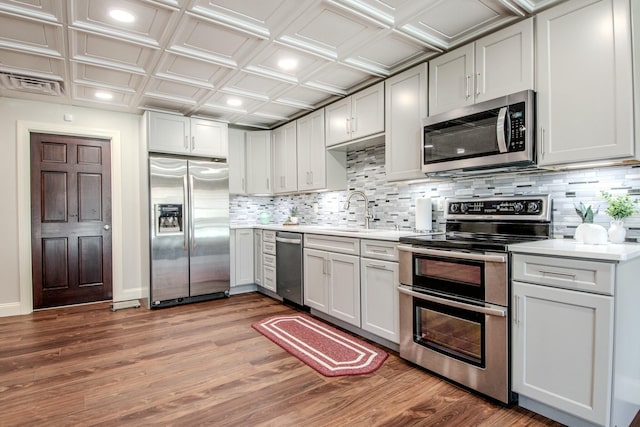 kitchen with an ornate ceiling, stainless steel appliances, light countertops, and a sink