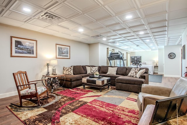 living area with wood finished floors, baseboards, and an ornate ceiling