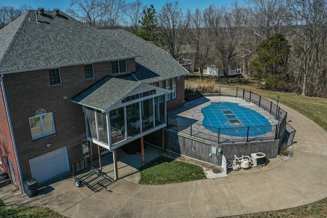 view of pool with a patio area, fence, a fenced in pool, and a sunroom