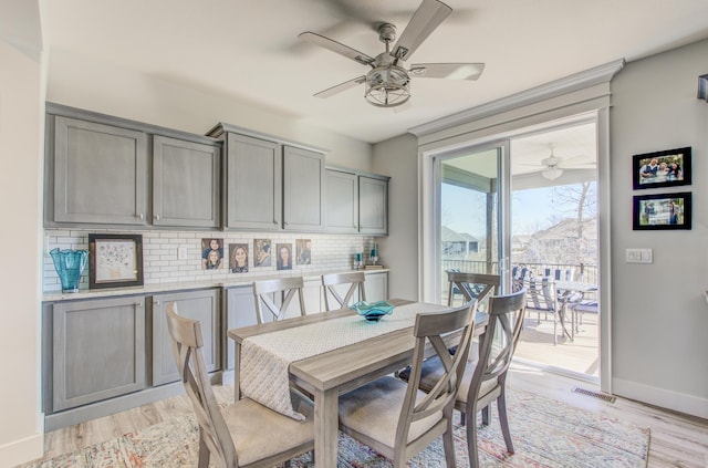 dining area featuring visible vents, baseboards, light wood-style floors, and a ceiling fan