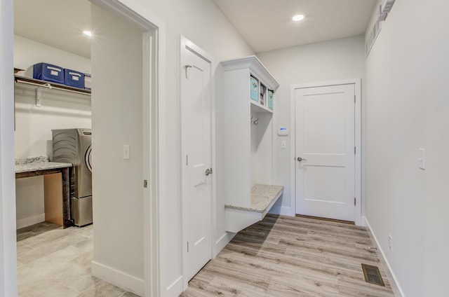 mudroom with visible vents, washer / clothes dryer, light wood-type flooring, and baseboards