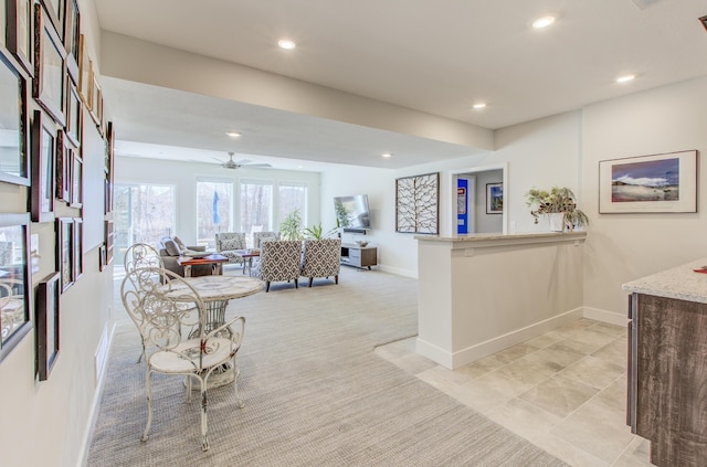 living area featuring a ceiling fan, recessed lighting, light colored carpet, and baseboards