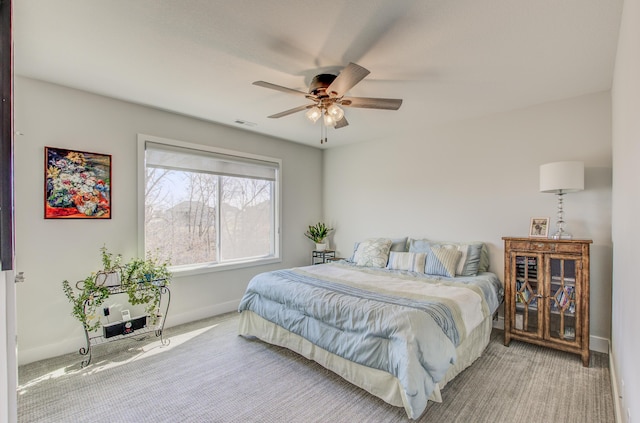 carpeted bedroom featuring visible vents, baseboards, and ceiling fan